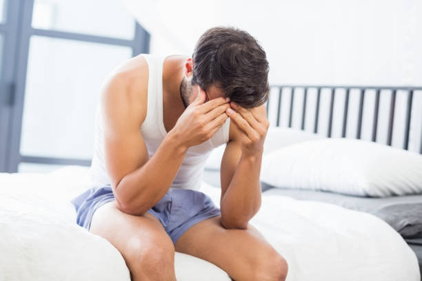 istock Tensed young man sitting on bed 668596872