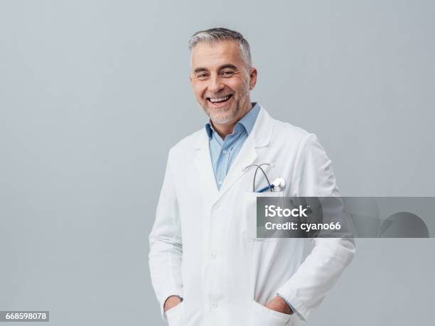 Cheerful Doctor Posing Stock Photo - Download Image Now - Doctor, Portrait, Lab Coat