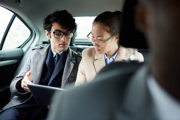 istock Business People Discussing Document in Car 668600028