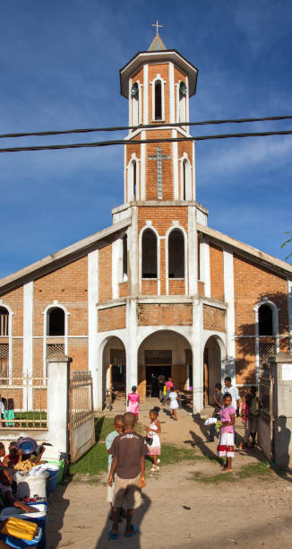 People flock towards the church of Ambanja, Northern Madagascar, at an early sunday morning with low sun.