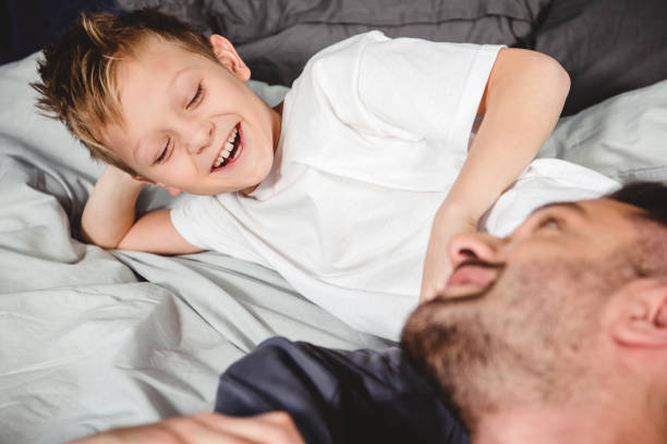 istock Happy father and son on bed 668602320