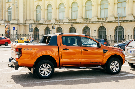 Bucharest: Beautiful and powerful orange Ford Ranger (codenamed T6) Wildtrack parked in center of Bucharest. Ford Wildtrack is a midsize pickup truck produced by Ford Motor Company.