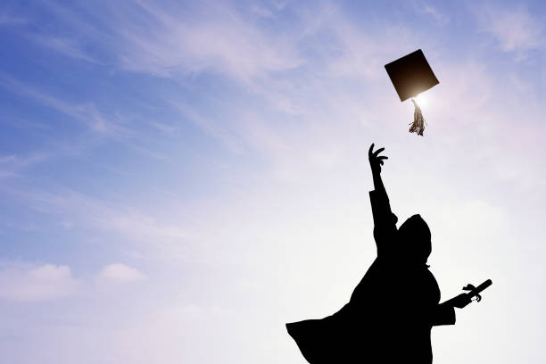 istock Graduate students tossing up hats over sky 668607162