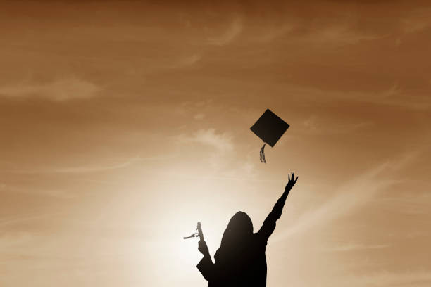 istock Graduate students tossing up hats over sky 668607166
