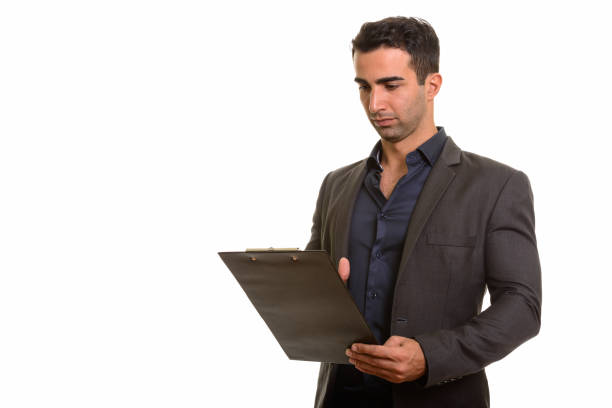 istock Young handsome Persian businessman reading on clipboard 668610464