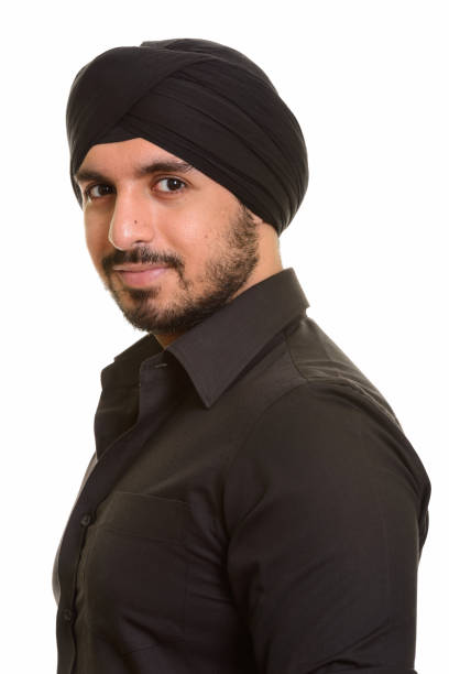istock Face of young handsome Indian Sikh man looking at camera while wearing turban 668613708