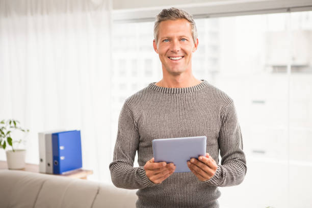 istock Smiling casual businessman with tablet 668614924