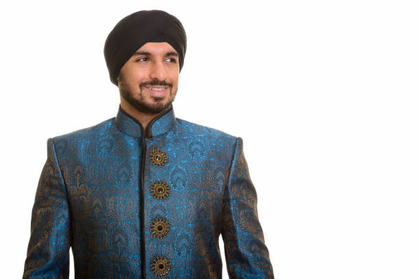 Young happy Indian Sikh man smiling and thinking while wearing traditional clothes horizontal shot