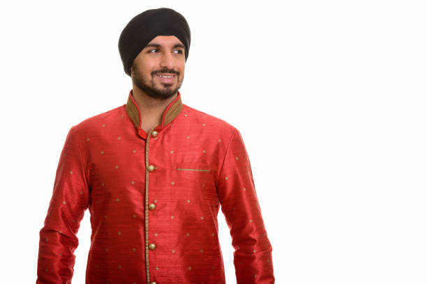Young happy Indian Sikh man thinking while wearing traditional clothes horizontal shot