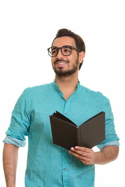 istock Young happy Indian man smiling and holding book while thinking 668616606