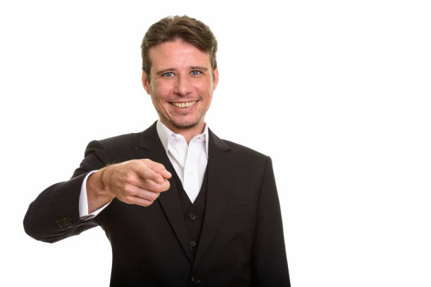 istock Happy businessman smiling while pointing at camera 668620872