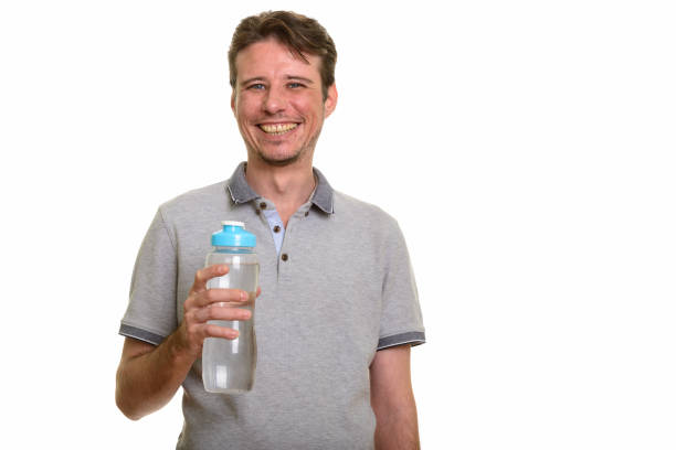 istock Happy handsome man smiling while holding water bottle 668624088