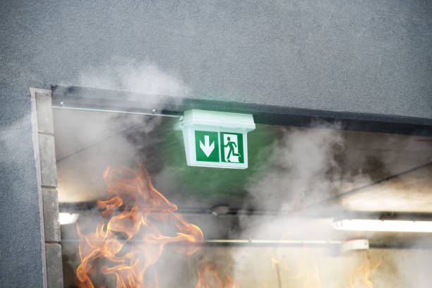 Salida de incendio de emergencia con humo y llamas de fuego - foto de stock