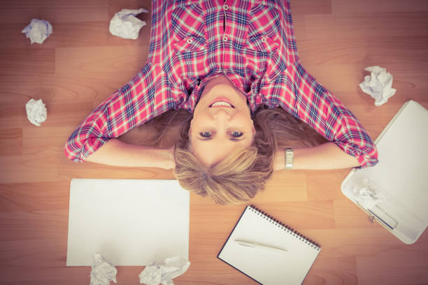 istock Smiling woman lying on floor surrounded by papers 668640754