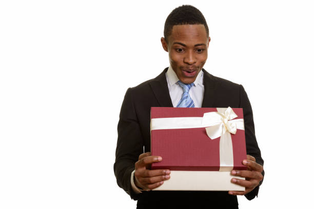 istock Young African businessman opening gift box and looking surprised 668641852