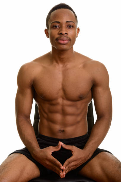 istock Young African man sitting on chair shirtless 668642092