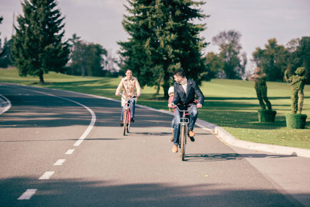 istock Happy family riding bicycles in park 668644268