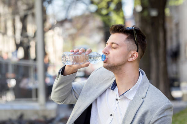 istock young businessman drinking water from plastic bottle 668644836