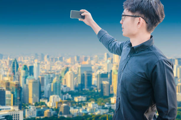 istock Young business man using laptop and digital tablet cityscape background 668650348