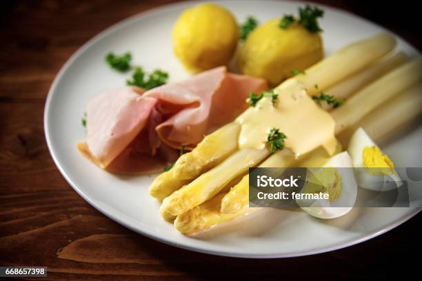 White Asparagus With Potatoes Ham Egg And Sauce Dark Wood Stock Photo - Download Image Now