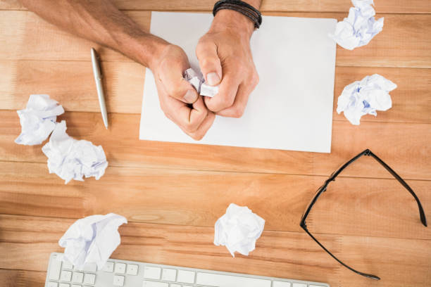 istock Hands crumpling paper on wooden desk 668658462