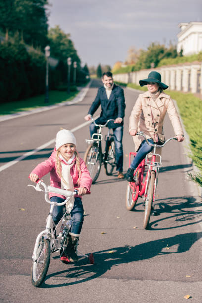 istock Cheerful family biking in park 668658506