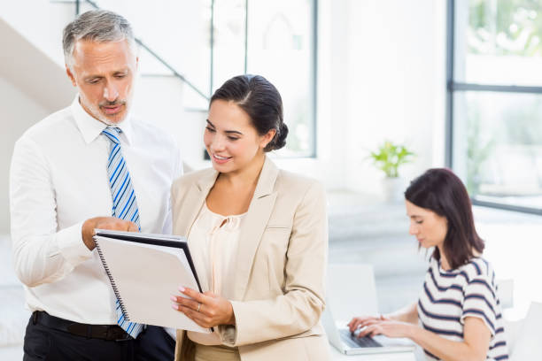 istock Businessman and businesswoman looking at diary 668661676