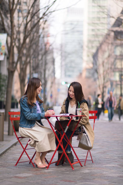 istock Young women having tea break at street cafe 668671262