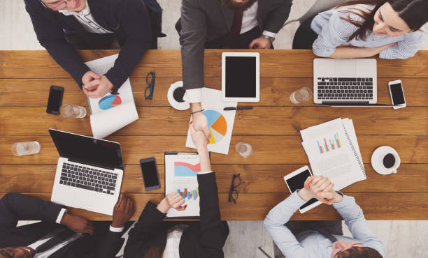 istock Business people group handshake in office, top view 668684356
