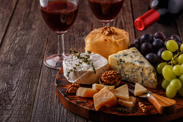 istock Cheese, nuts, grapes and red wine on wooden background 668684372