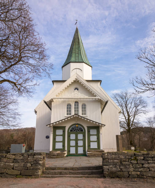 istock White church and blue sky with small clouds in Norway, vertical image 668684390