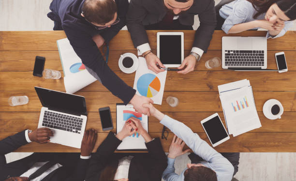 istock Business people group handshake in office, top view 668684638
