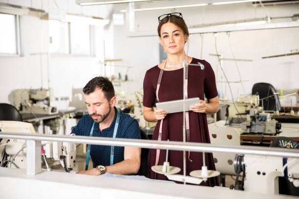 istock Young woman supervising some workers 668684676