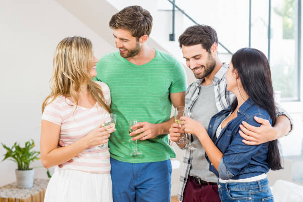 istock Two cute couple smiling with alcohol glass in hand 668685186
