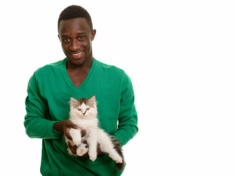 Young happy African man smiling and holding cute cat horizontal shot