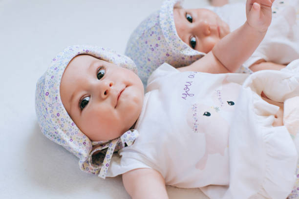 divertenti gemelli sorelle bambini - twin newborn baby baby girls foto e immagini stock