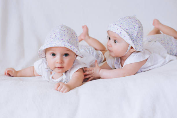 istock Twin sisters babies lying together . White background 668697612