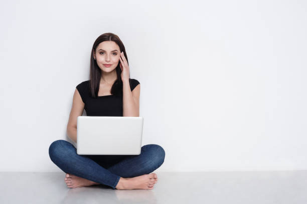 istock Woman using laptop sitting on the studio floor 668697972