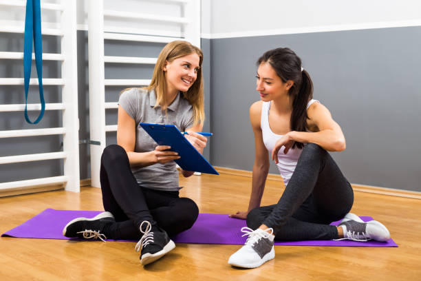 Woman and her personal trainer talking stock photo