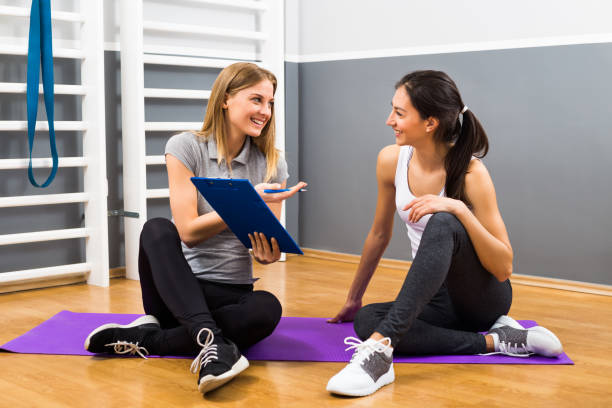 istock Woman and her personal trainer talking 668698850