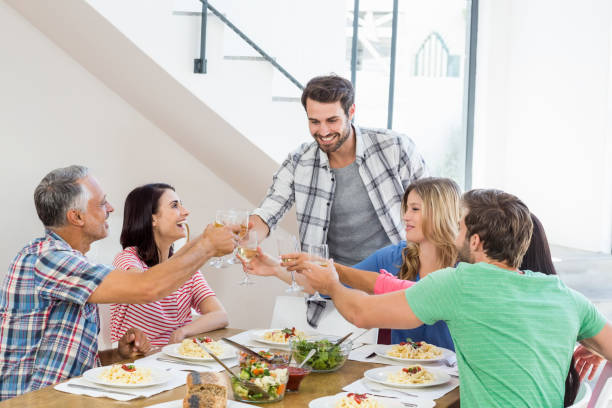 istock Friends toasting wine glasses while having a meal 668702082