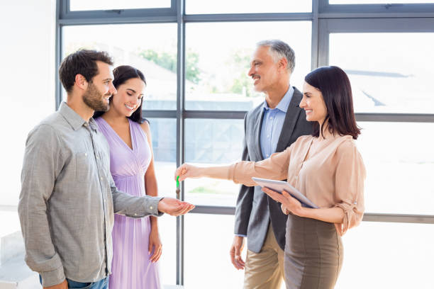istock Real-estate agent giving keys to couple 668708020