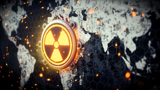 A 3D render of a world map outline with a nuclear warning symbol attached. The world map is very dirty and scratched with glowing particles of dust rotating in the air.\n\n\n