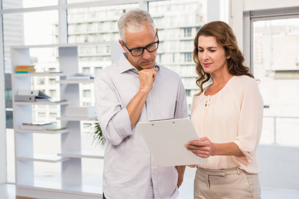 istock Casual business colleagues looking at clipboard 668711452