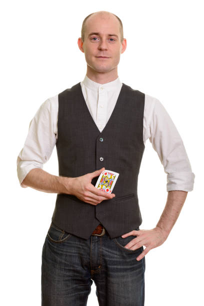 istock Bald handsome magician man standing while holding Jack of Diamonds card with hand on hip 668712456
