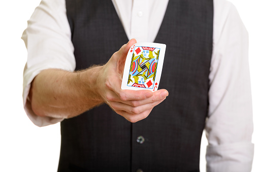 Hand of magician man holding and bending Jack of Diamonds card horizontal shot