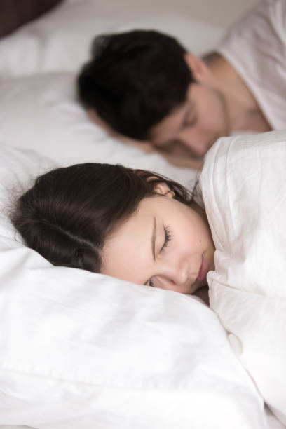 istock Beautiful young lady with beloved man sleeping in comfortable bed 668717828