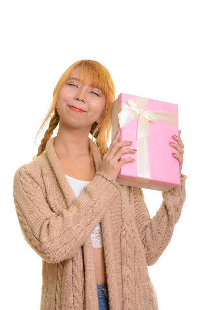 istock Young thoughtful Asian woman guessing gift box 668718162