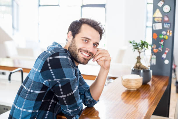 istock Portrait of happy man leaning on table 668721408