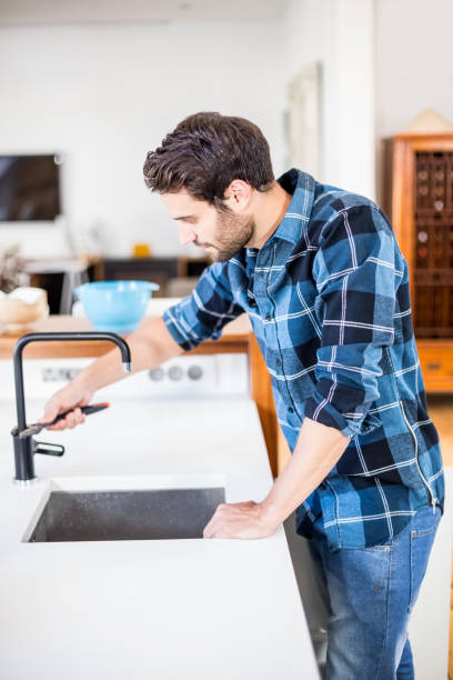 istock Man fixing tap with tool in the kitchen 668721554